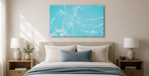 Blue abstract painting on a wall above a beige sofa with decorative elements.